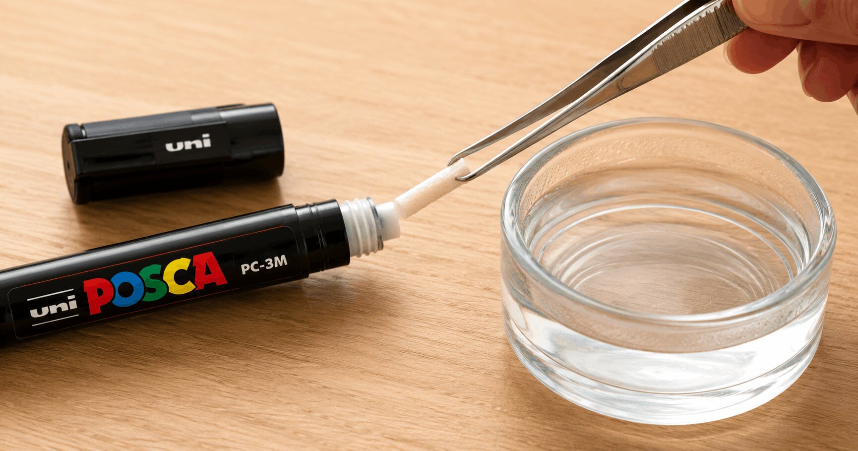 Tweezers removing a felt nib from a POSCA PC-3M pen for a warm-water soak