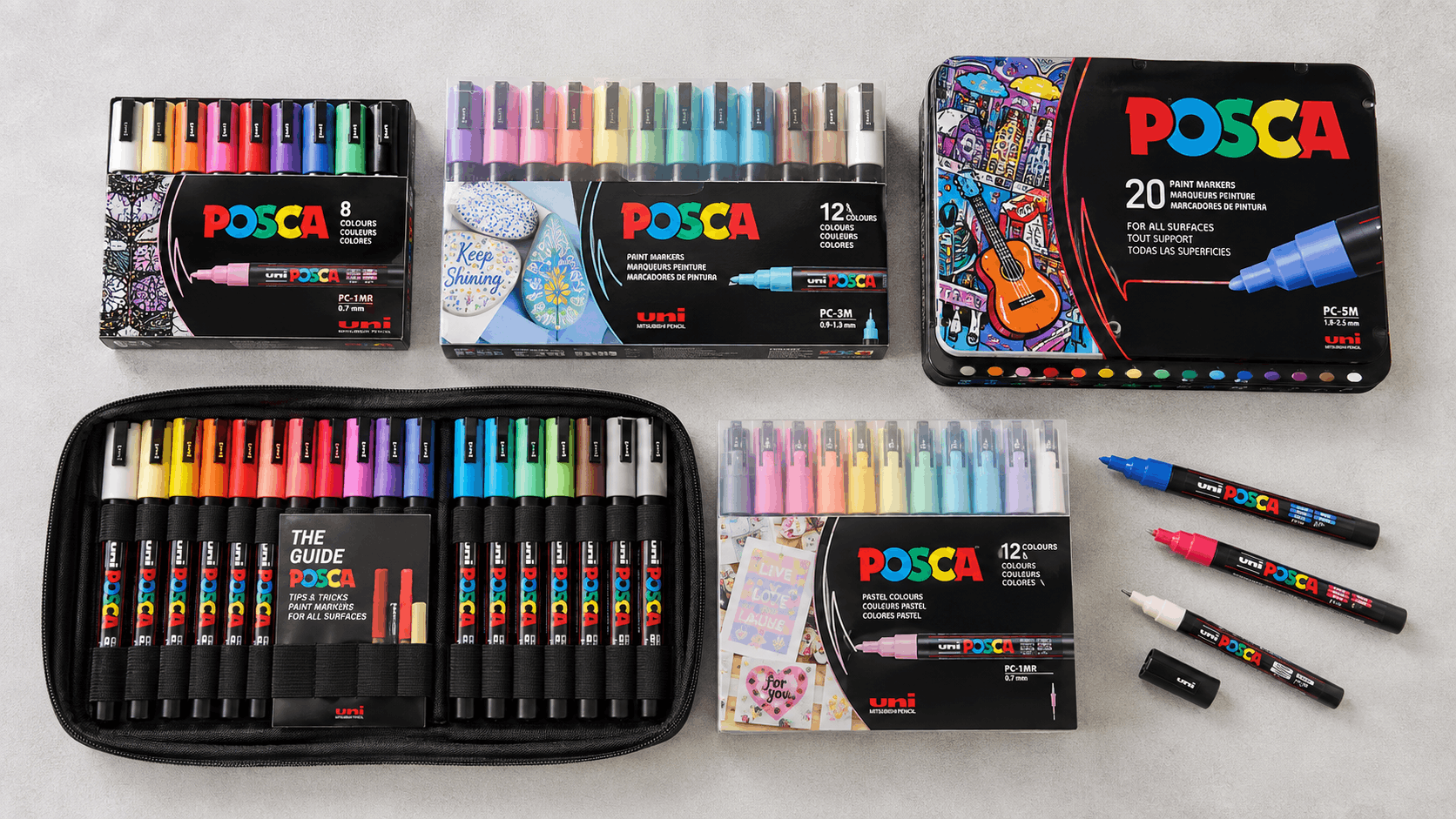 Several POSCA pen set boxes of different pack sizes and tip types laid flat side by side
