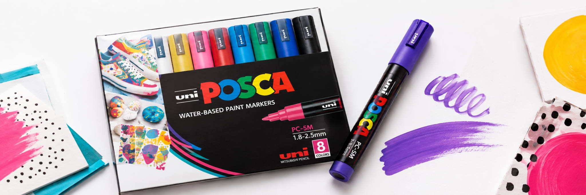 Single POSCA paint marker next to an assorted POSCA set box on a flat surface